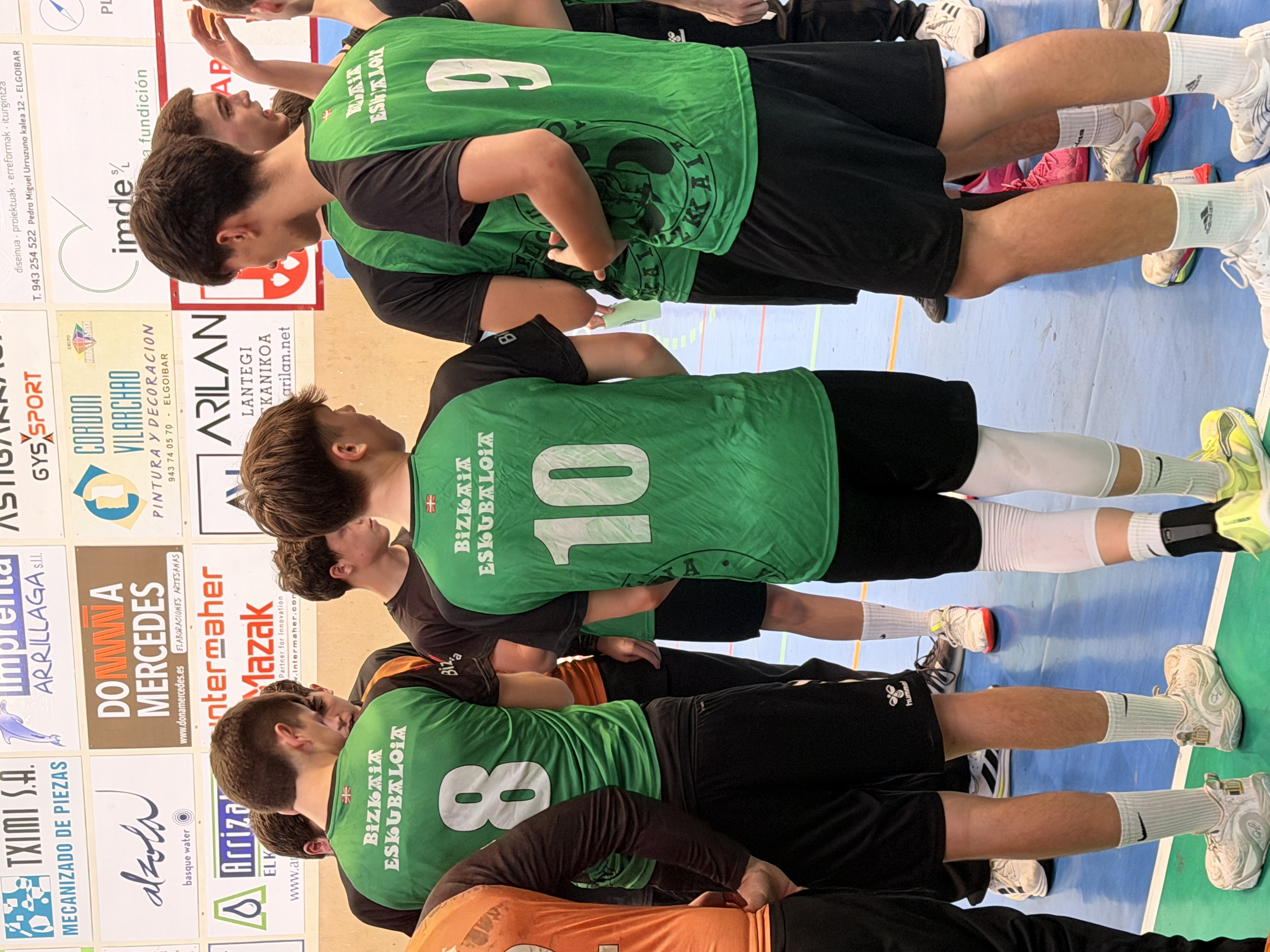 Jugadores de Bizkaia Eskubaloia con dorsales 8, 9 y 10 charlando durante un campus de balonmano